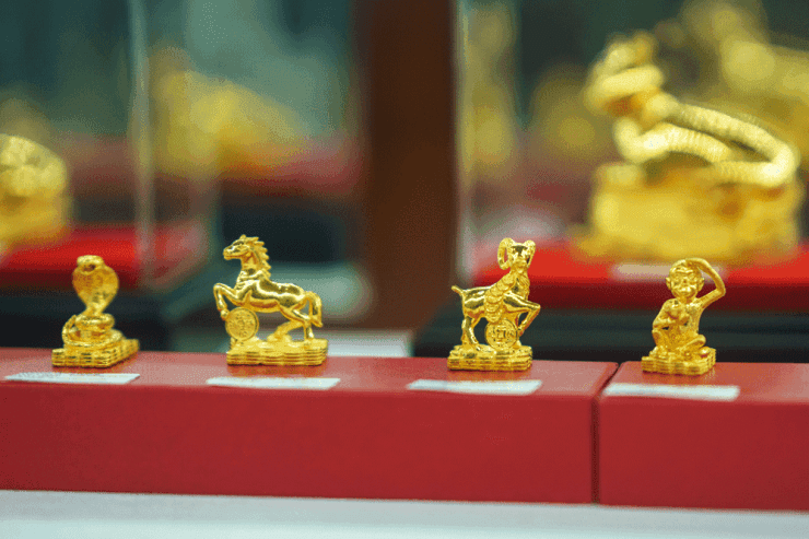 Các tượng vàng nhỏ hình linh vật, tượng trưng cho giá trị và sự đa dạng hóa của vàng như một tài sản trú ẩn.