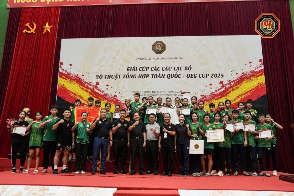 Các vận động viên và huấn luyện viên cùng nhau trên sân khấu tại lễ trao giải Giải vô địch các Câu lạc bộ Võ thuật tổng hợp quốc gia 2025.