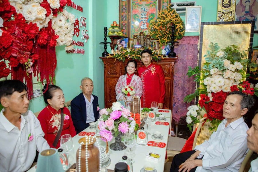 Chú rể Anh Vũ và cô dâu Chị Tiếp cùng gia đình trong buổi tiệc cưới ấm cúng, tượng trưng cho hạnh phúc mới.