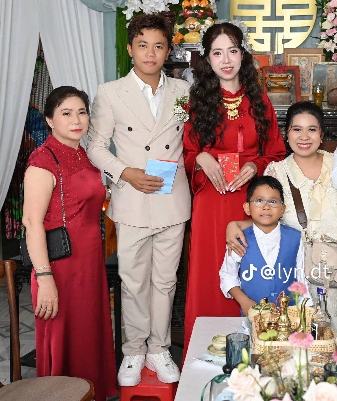 Chú rể đứng trên ghế để cao ngang cô dâu trong lễ cưới, biểu tượng cho tình yêu vượt qua định kiến chiều cao.
