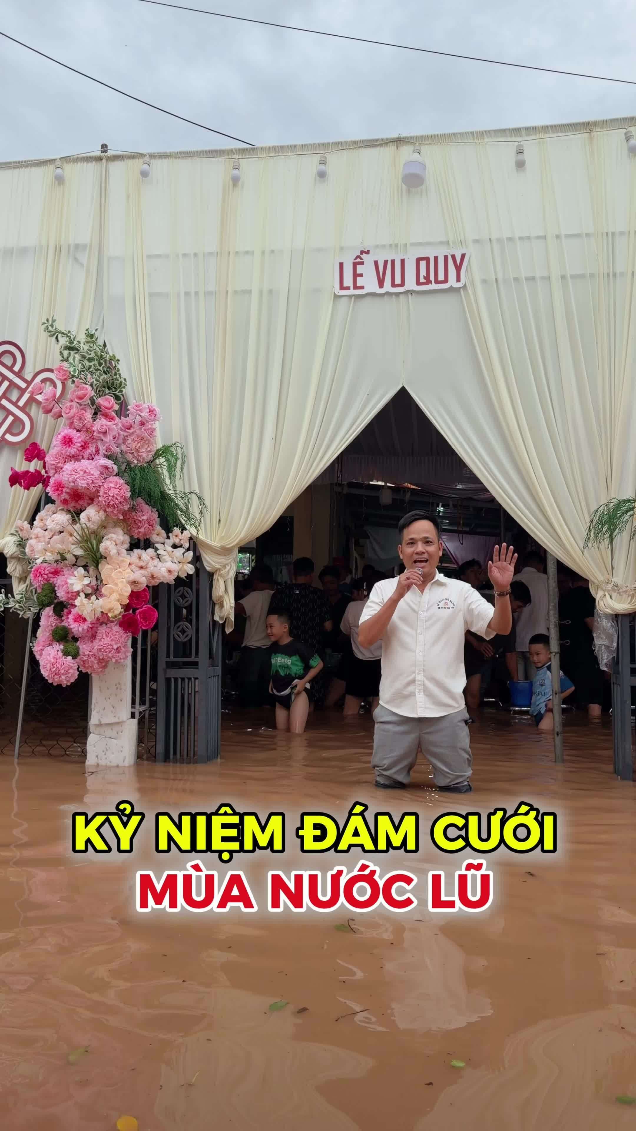 Chú rể Thái Huỳnh quỳ gối trước cổng cưới ngập nước, thể hiện tình yêu kiên cường vượt qua khó khăn.