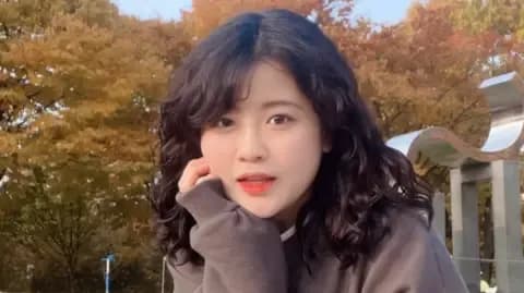 Chân dung Baek Se-hee, tác giả cuốn hồi ký nổi tiếng, với mái tóc xoăn và nụ cười nhẹ nhàng.