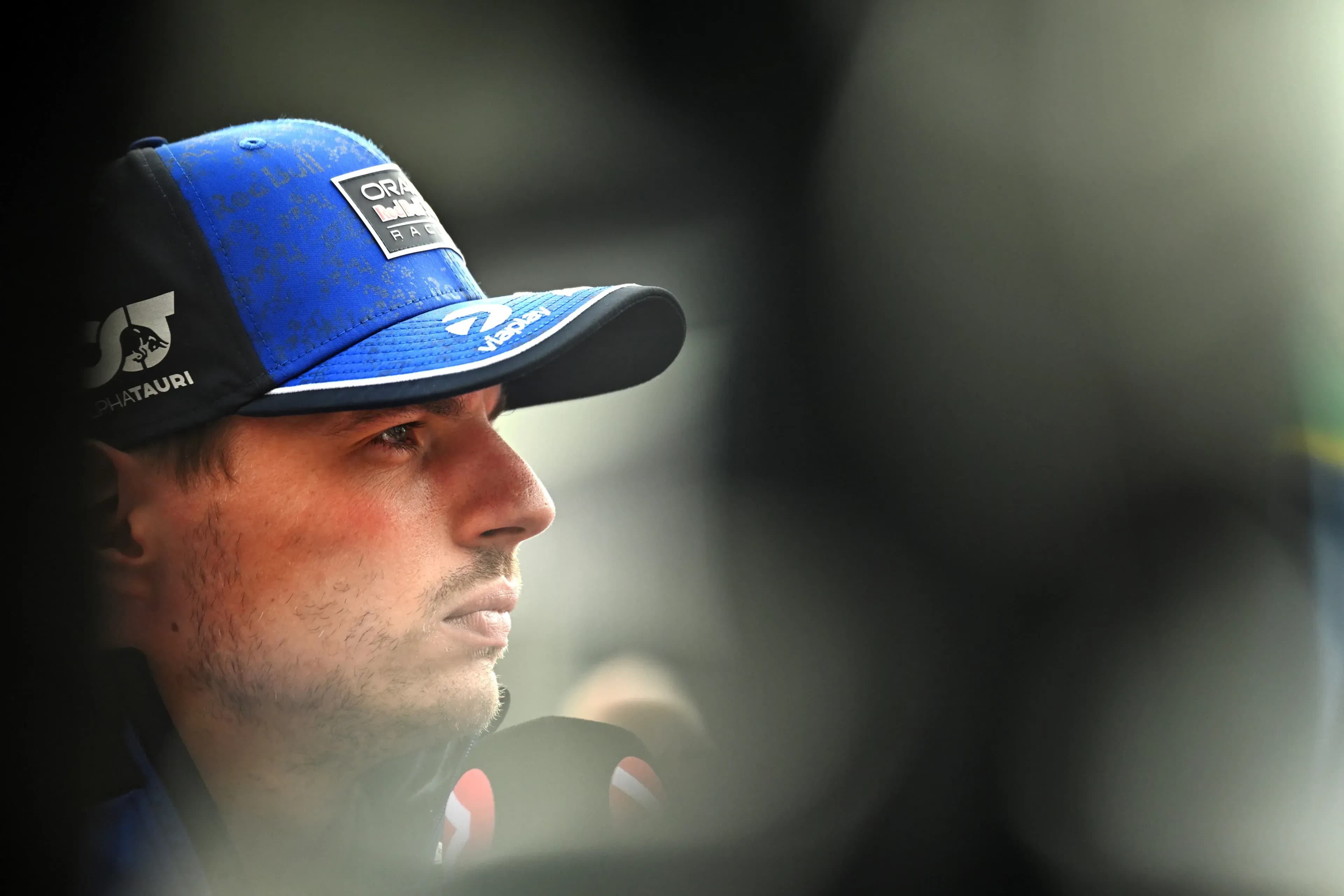 Chân dung cận cảnh tay đua Max Verstappen với vẻ mặt tập trung, thể hiện áp lực thể chất và tinh thần mà các tay đua F1 phải đối mặt.