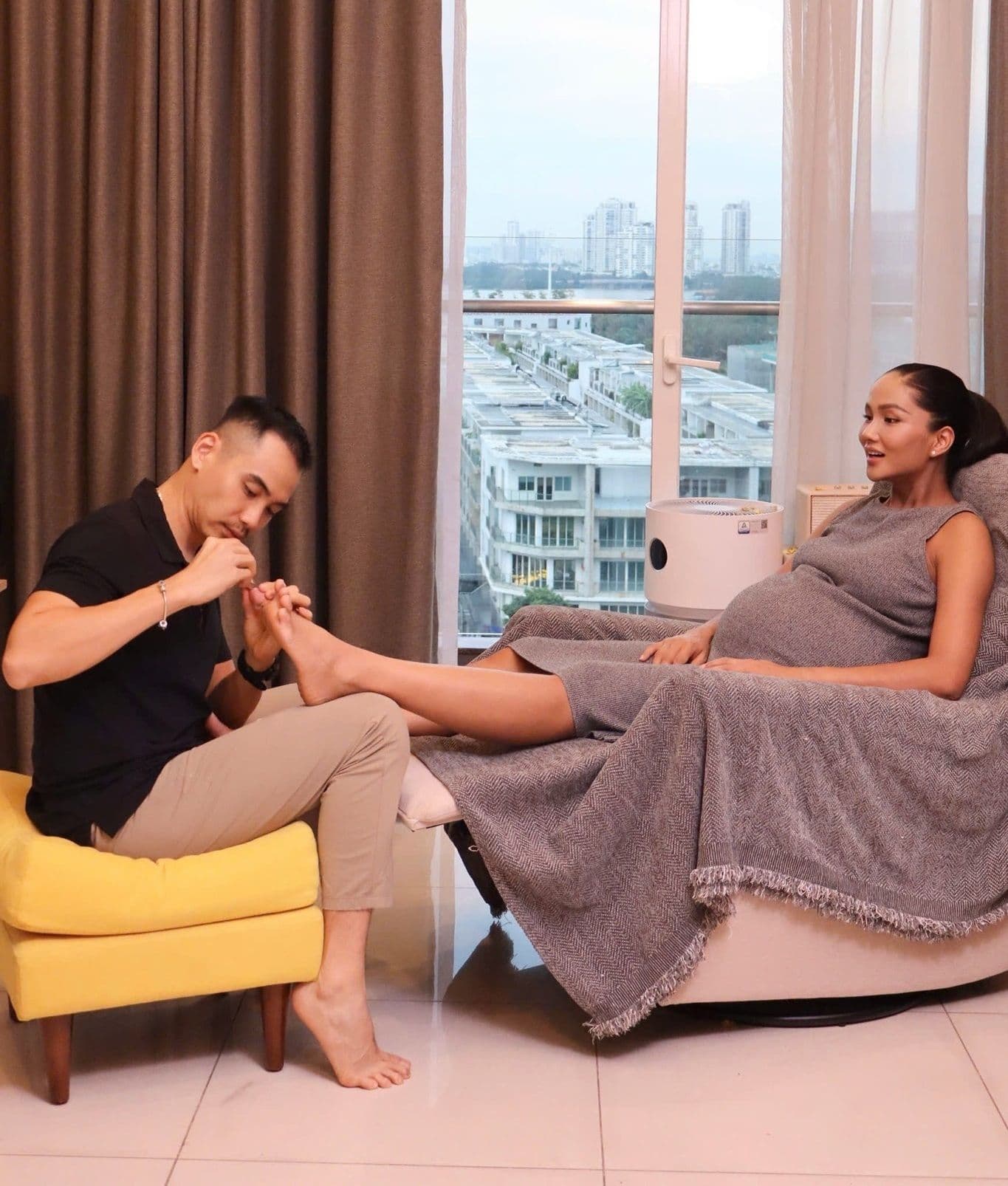 Chồng H'Hen Niê ân cần cắt móng chân cho vợ khi cô đang mang bầu, thể hiện sự chăm sóc chu đáo.