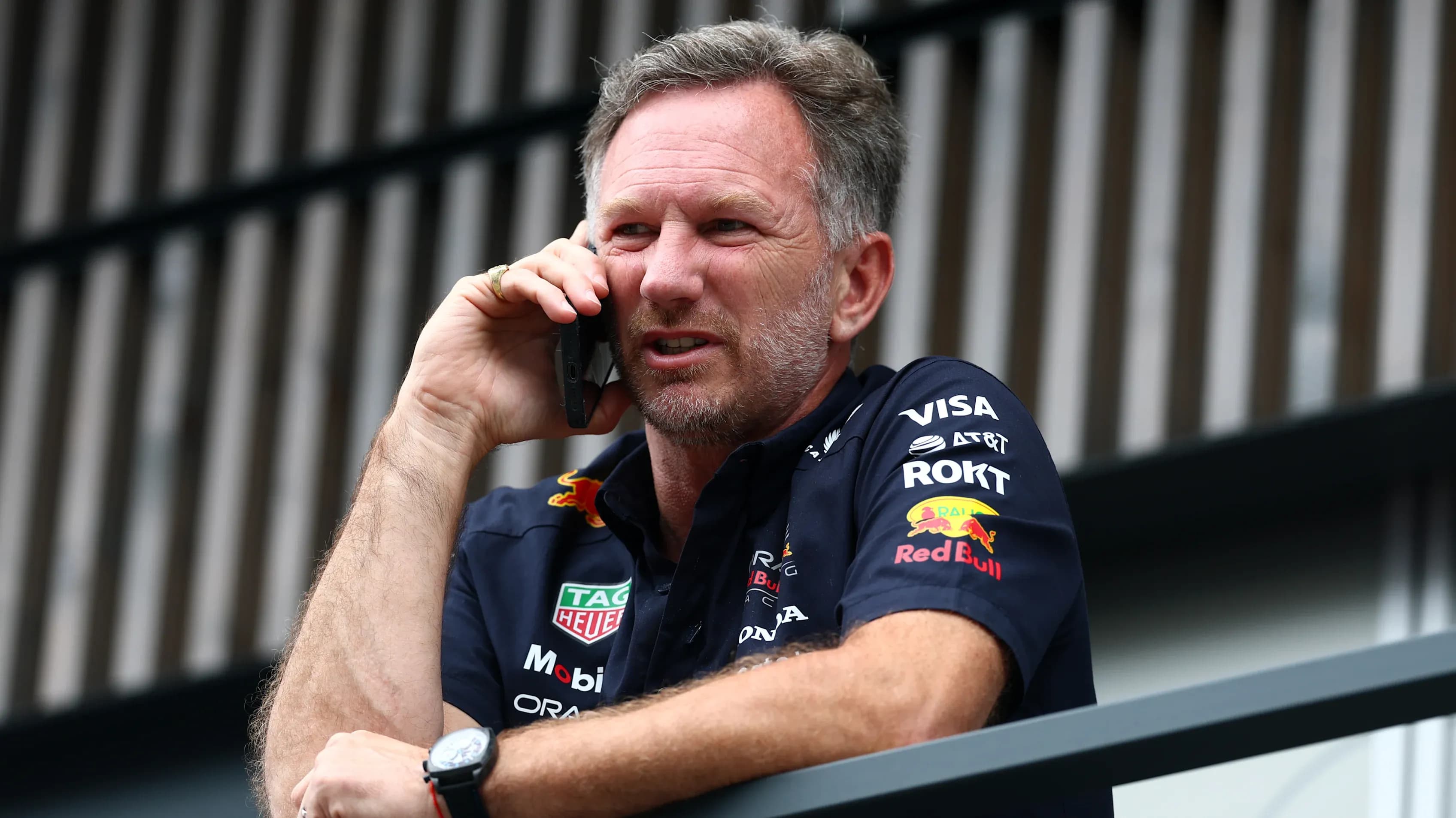 Christian Horner, lãnh đội Red Bull Racing, đang nghe điện thoại, tượng trưng cho áp lực và rạn nứt nội bộ