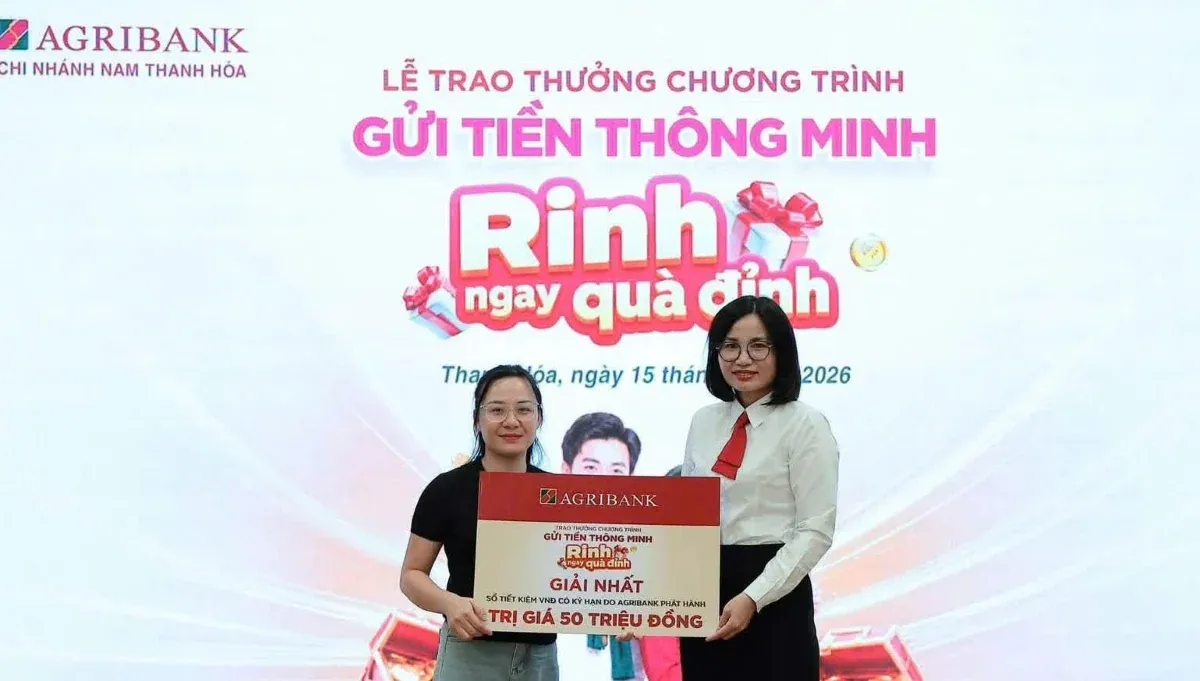 Cán bộ Agribank trao giải nhất chương trình tiết kiệm cho khách hàng, thể hiện hoạt động gắn kết với cộng đồng