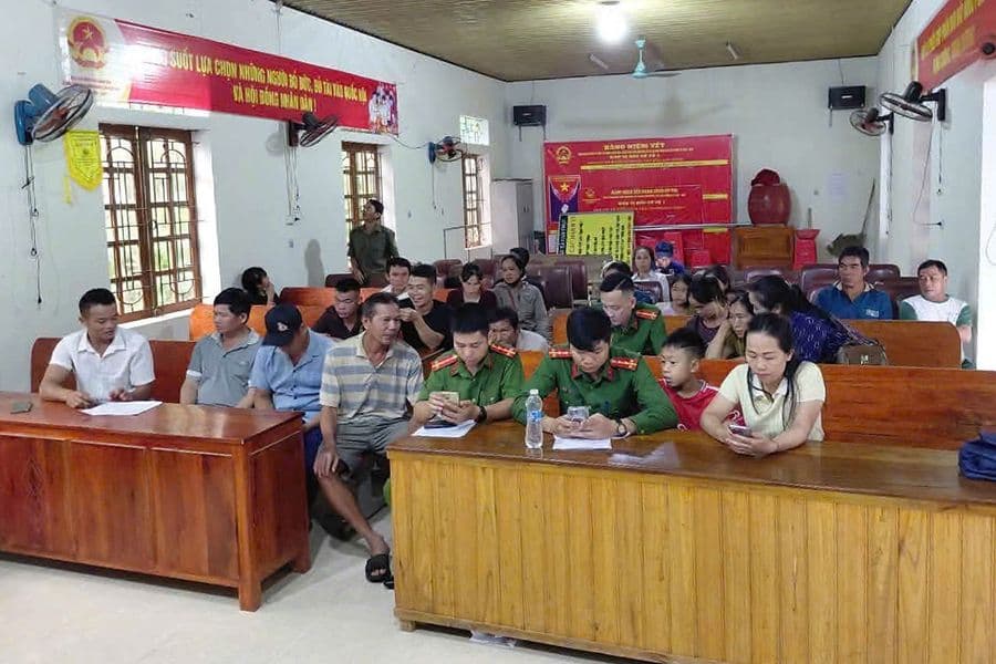 Cán bộ công an hỗ trợ người dân kích hoạt tài khoản định danh điện tử VNeID, thể hiện sự tiếp cận từ màn hình đến làng xã.
