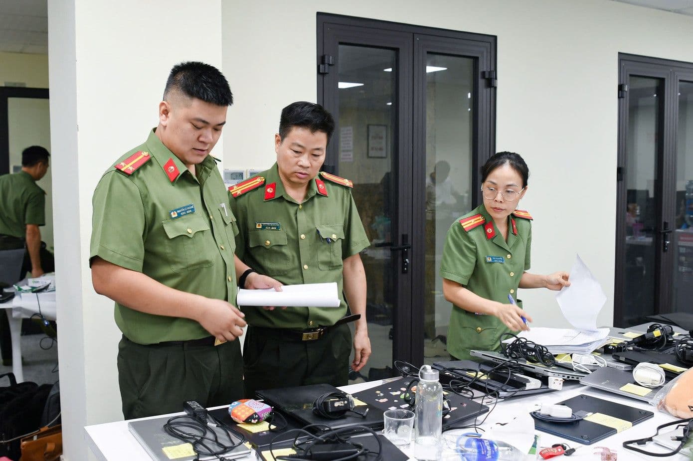 Cán bộ công an kiểm tra tài liệu và thiết bị, minh chứng cho việc nhận diện các dấu hiệu lừa đảo
