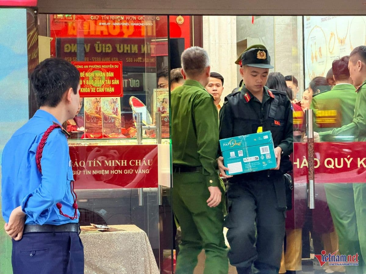 Cán bộ công an mang thùng tài liệu ra khỏi cửa hàng Bảo Tín Minh Châu trong quá trình điều tra.