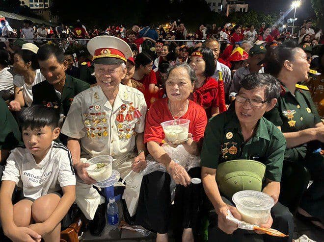 Cán bộ công an phường Ô Chợ Dừa trao xôi cháo ấm áp cho người dân và cựu chiến binh chờ đợi tổng duyệt