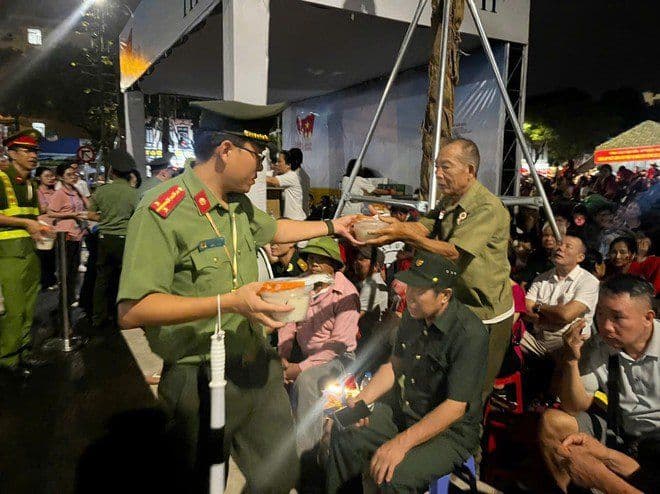Cán bộ công an trao tặng suất ăn cho cựu chiến binh, thể hiện tình đoàn kết và sự quan tâm