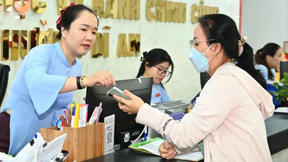 Cán bộ hành chính công hướng dẫn người dân làm thủ tục, thể hiện sự tương tác giữa khung pháp lý và con người trong công việc.