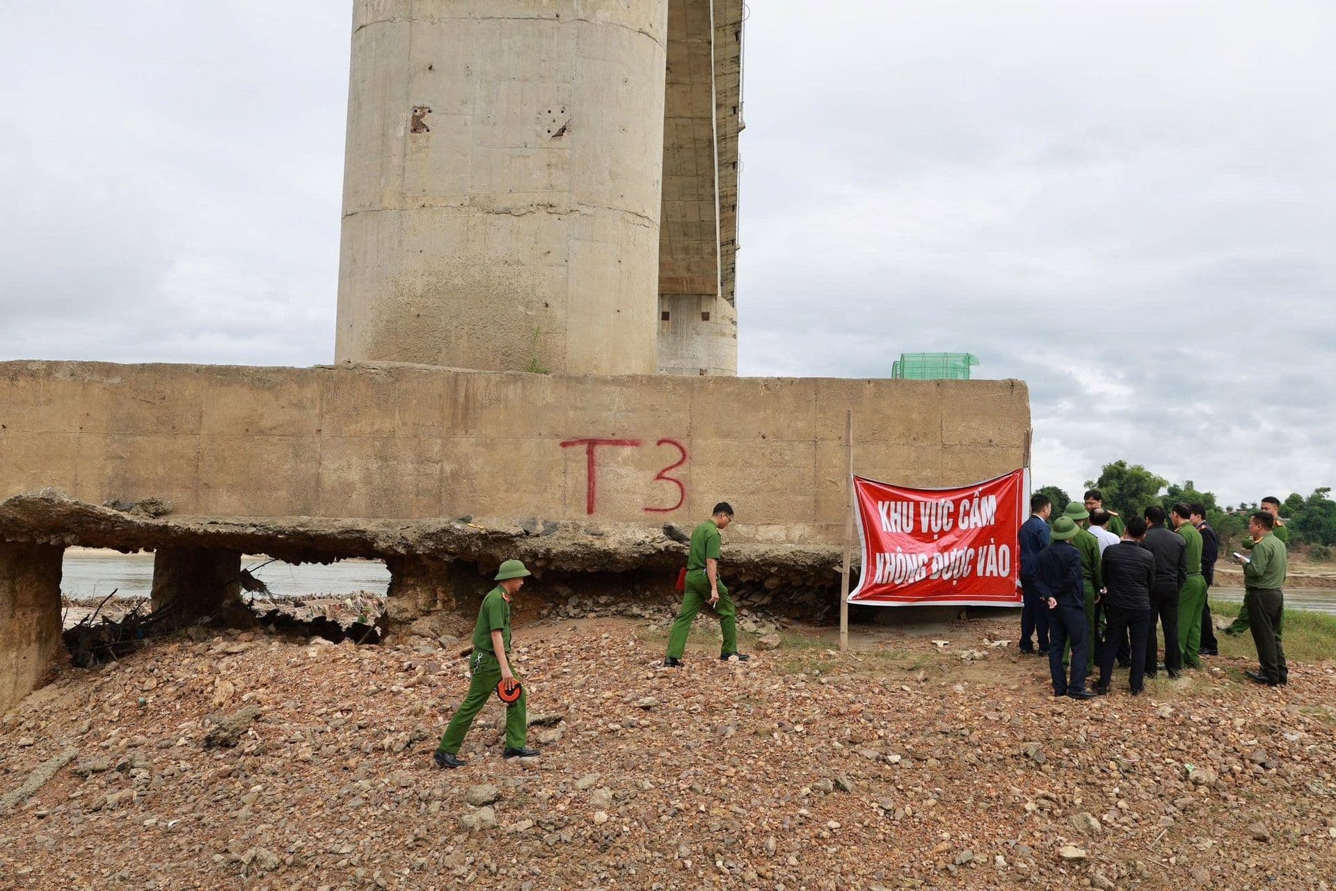Cán bộ kiểm tra cầu Sông Lô bị hư hại tại trụ T3 với biển báo khu vực cấm.