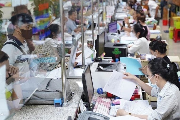 Cán bộ tiếp nhận hồ sơ giấy tờ tại trung tâm hành chính công, thể hiện quy trình hành chính truyền thống