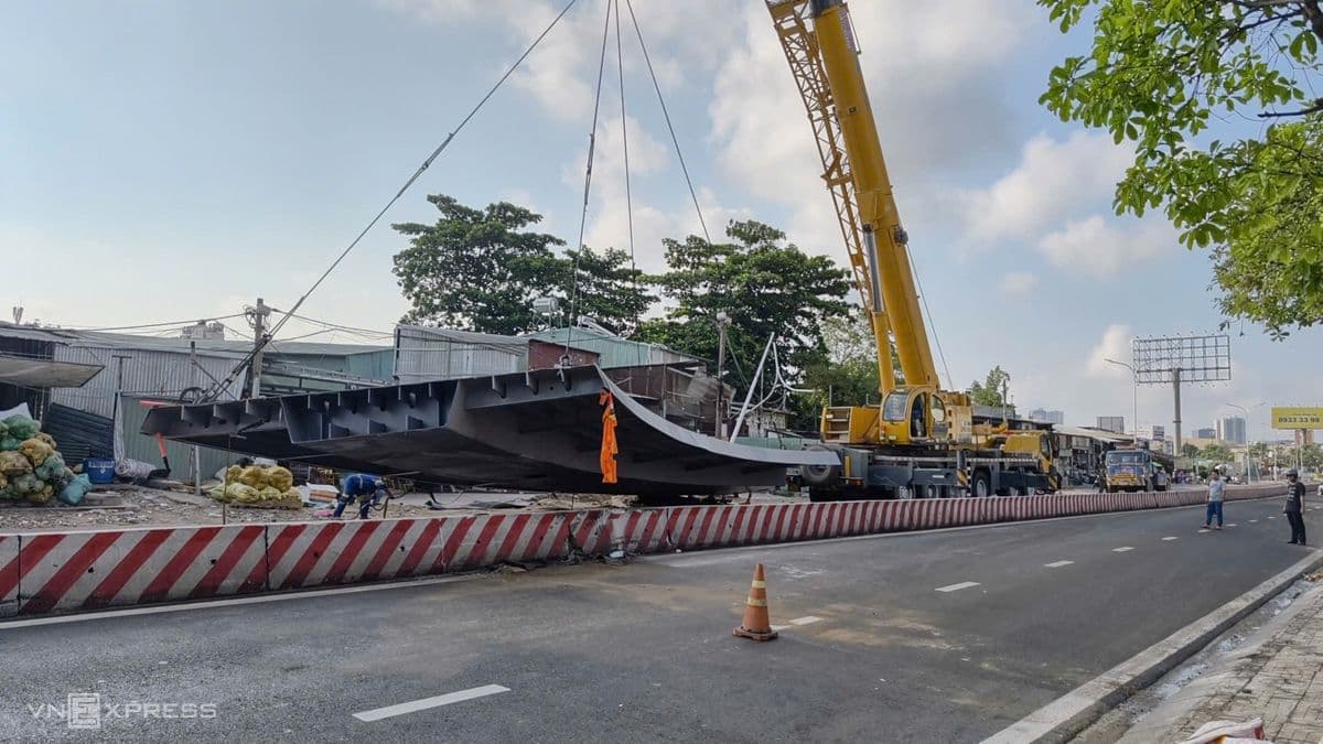 Cần cẩu lớn đang di chuyển một cấu kiện thép trên công trường, tượng trưng cho nỗ lực đầu tư hạ tầng và xây dựng an toàn giao thông tại TP.HCM.