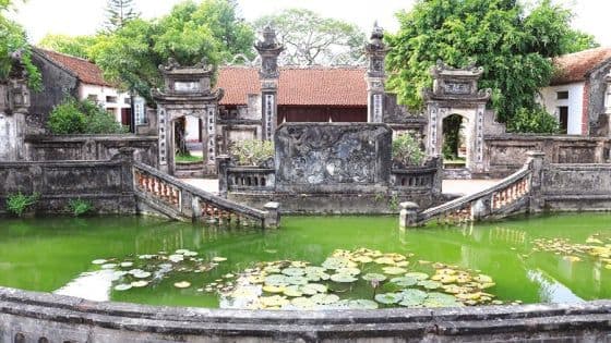 Cổng chùa cổ kính với hồ sen, biểu tượng cho việc Hà Nội giữ vững bản sắc văn hóa truyền thống giữa dòng chảy phát triển.