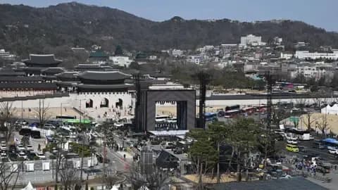 Công nhân đang dựng sân khấu cho buổi hòa nhạc trở lại của nhóm nhạc K-pop BTS trước Cổng Gwanghwamun, thể hiện quy mô văn hóa fandom.