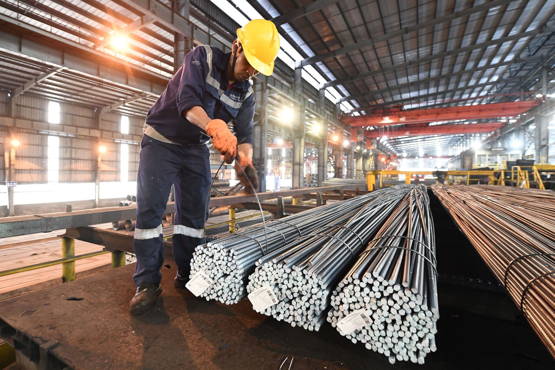 Công nhân đang kiểm tra thép tại nhà máy, tượng trưng cho sự kiến tạo và đóng góp vào di sản quốc gia