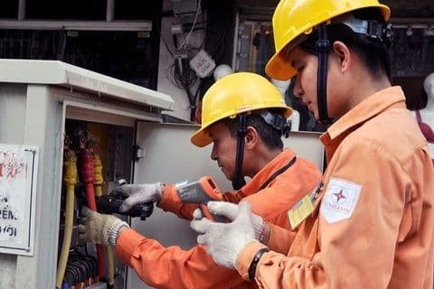 Công nhân điện lực đang kiểm tra hệ thống, tượng trưng cho hạ tầng năng lượng