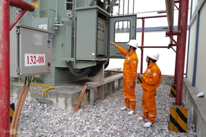Công nhân điện lực kiểm tra trạm biến áp, biểu tượng cho hạ tầng điện đang chịu áp lực cao.
