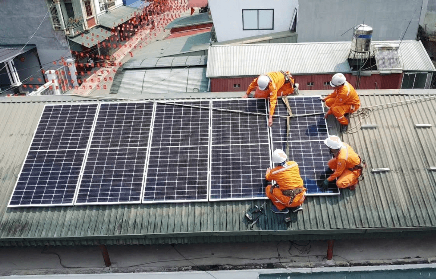 Công nhân lắp đặt các tấm pin điện mặt trời trên mái nhà