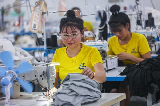 Công nhân may mặc đang làm việc, minh họa cho người lao động và ngành công nghiệp chịu tác động của chính sách tiền lương.