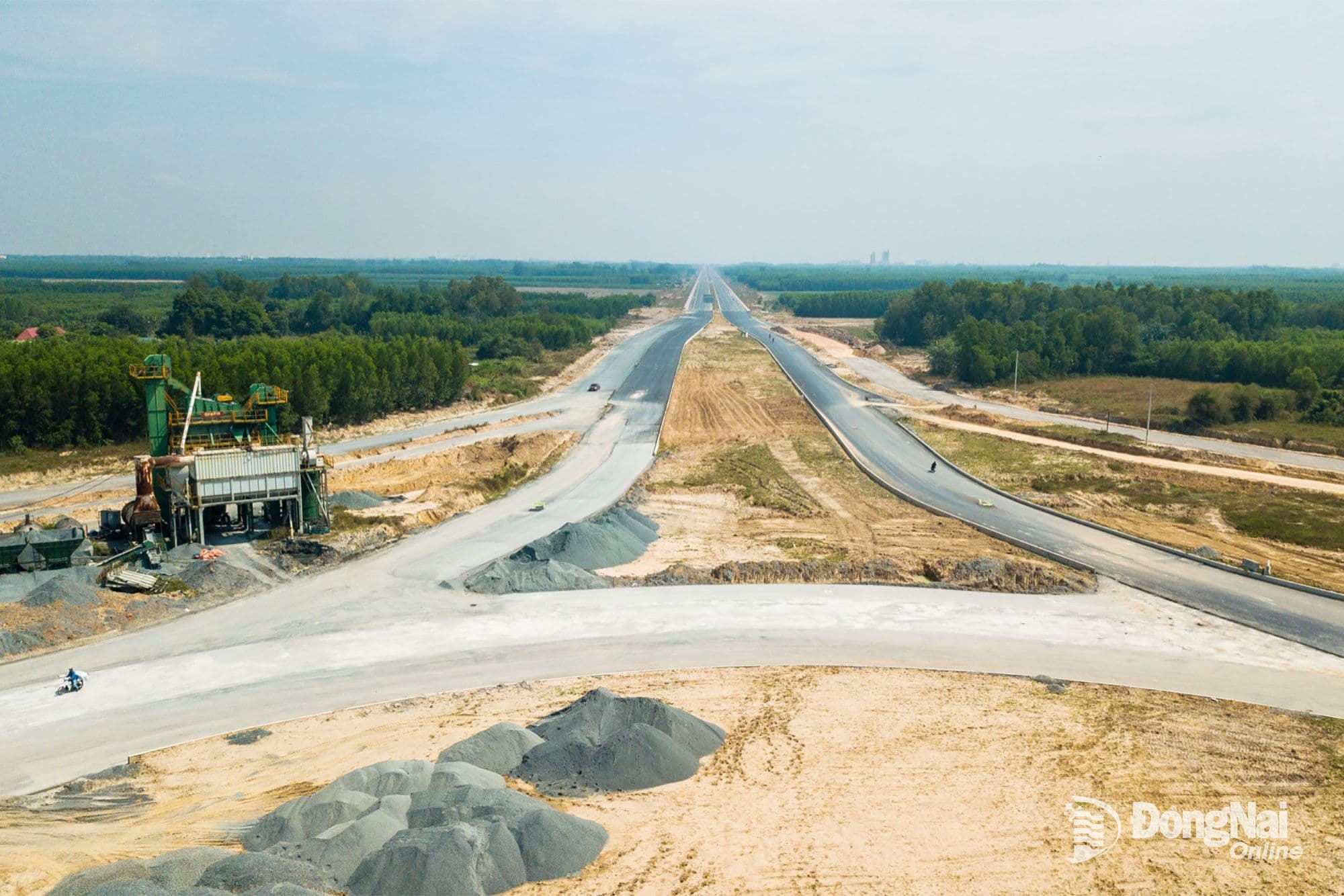 Công trường xây dựng đường giao thông với máy móc và vật liệu, minh họa tiến độ thi công các hạng mục hạ tầng quan trọng.