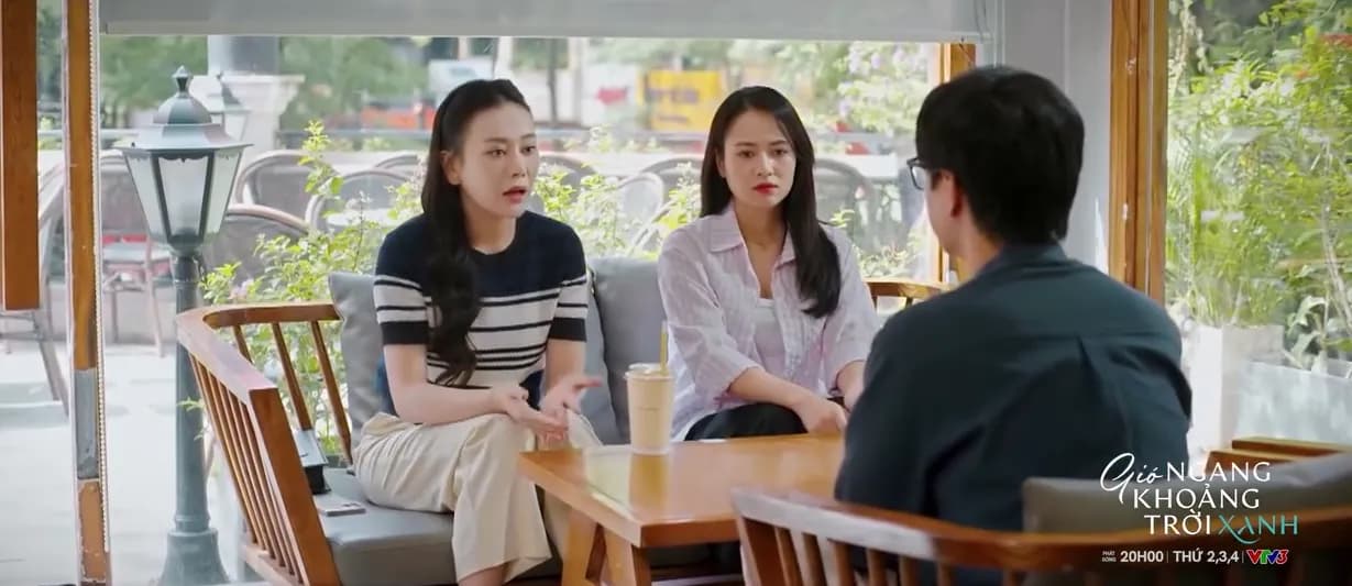 Cảnh phim 'Gió Ngang Khoảng Trời Xanh' trên VTV3, với hai người phụ nữ và một người đàn ông đang trò chuyện trong quán cà phê.