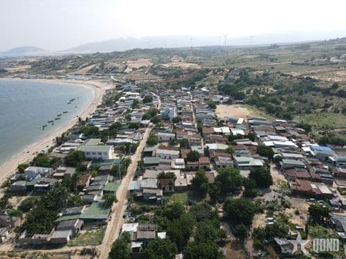 Cảnh quan ven biển với tuabin gió, tượng trưng cho xu hướng điện hóa và các giải pháp năng lượng thay thế để ứng phó với giá nhiên liệu