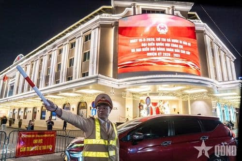 Cảnh sát giao thông điều tiết dòng xe tại nút giao đô thị, nhấn mạnh sự tương tác giữa con người và phương tiện.