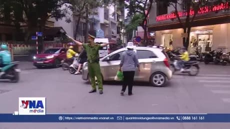 Cảnh sát giao thông điều tiết phương tiện trên đường phố Hà Nội, tượng trưng cho nỗ lực lập lại trật tự đô thị và quản lý vỉa hè.