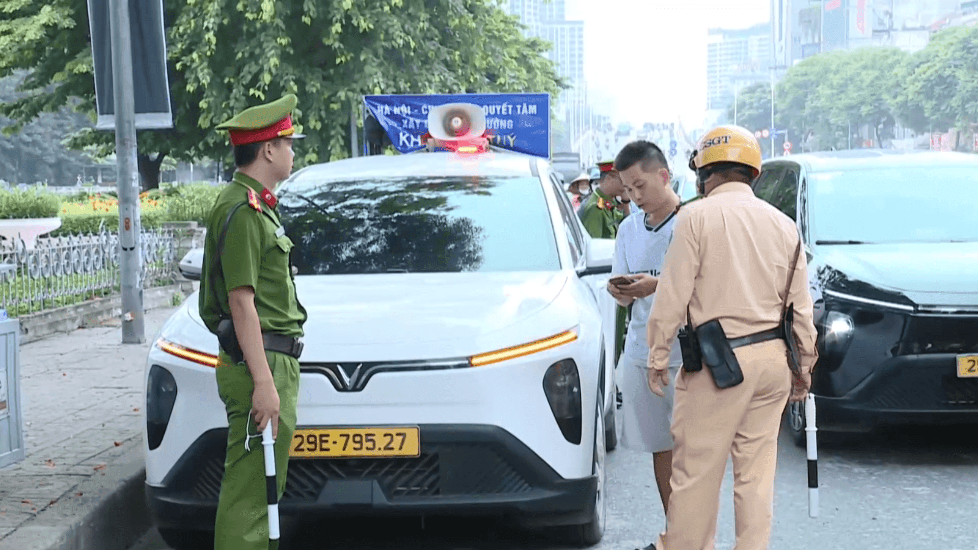 Cảnh sát giao thông kiểm tra giấy tờ một tài xế bên cạnh xe ô tô, thể hiện phương pháp quản lý đỗ xe phản ứng mà Việt Nam cần chuyển đổi.