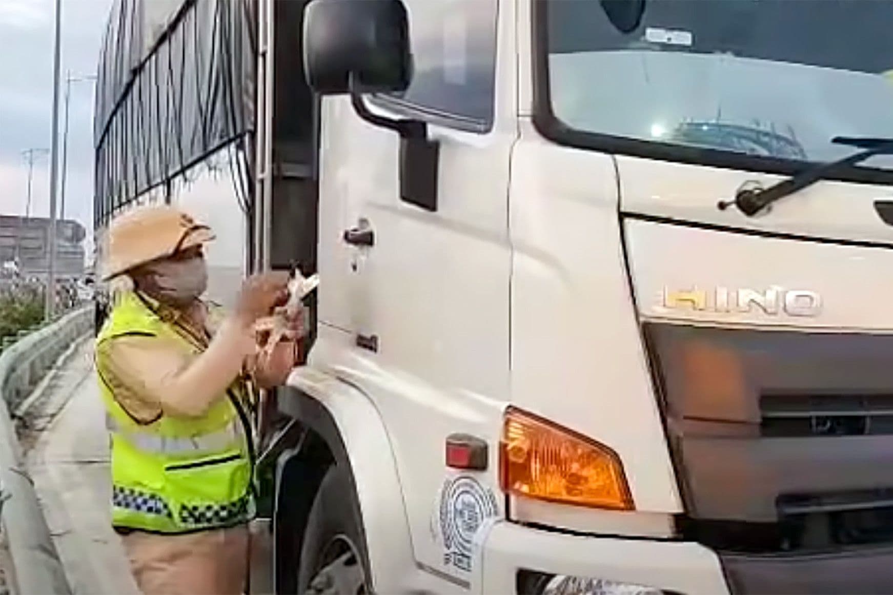Cảnh sát giao thông kiểm tra xe tải trên đường, thể hiện vai trò thực thi pháp luật và tương tác với người dân.