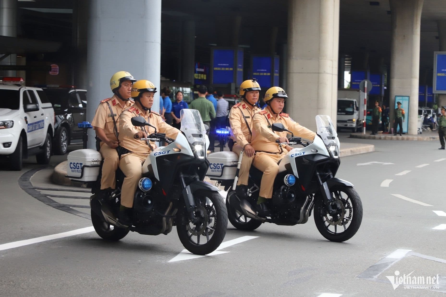 Cảnh sát giao thông trên mô tô tuần tra, tượng trưng cho sự quản lý và kết nối trong hệ thống giao thông sân bay tương lai.