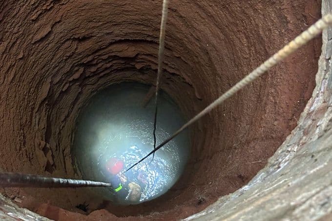 Cảnh sát đu dây xuống giếng sâu tối tăm trong chiến dịch giải cứu người bị nạn.