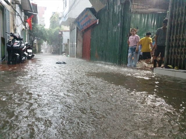 Cảnh tượng đường phố Hà Nội ngập sâu trong nước sau mưa lớn, thể hiện thách thức về thoát nước đô thị.