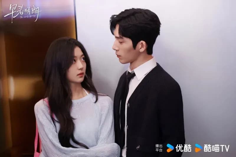 Cặp đôi chính trong "Đầu Xuân Tươi Sáng" đứng gần nhau trong thang máy công sở