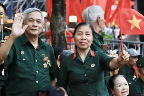 Cặp đôi cựu chiến binh tự hào vẫy cờ Việt Nam, biểu tượng của di sản và lòng tự tôn dân tộc.