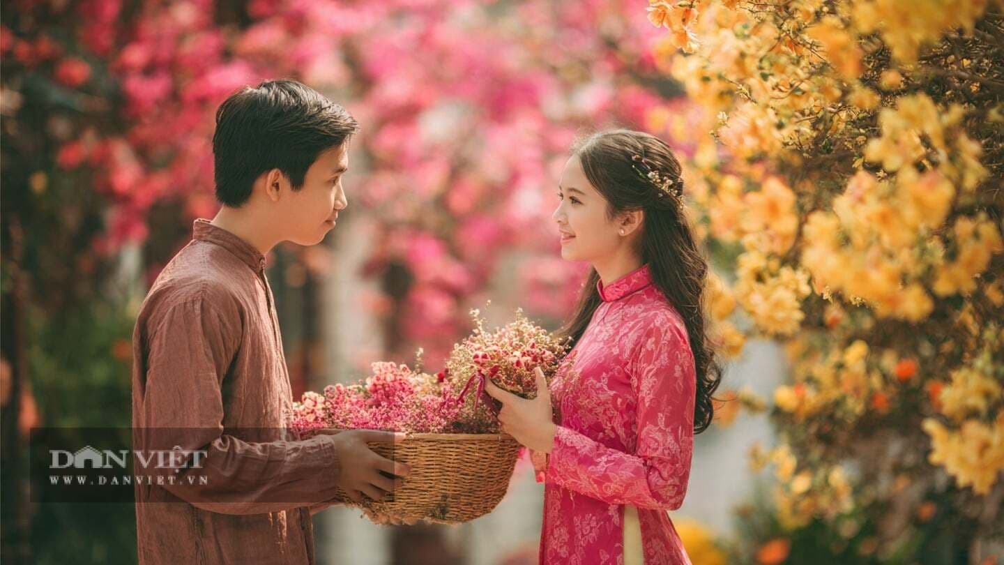 Cặp đôi Việt Nam trong trang phục truyền thống, trao nhau giỏ hoa tươi thắm, thể hiện sự gắn kết và hy vọng vào tương lai tươi sáng của phụ nữ Việt.