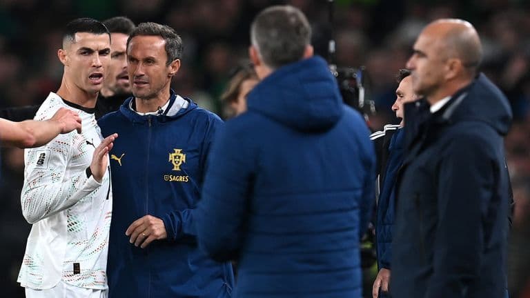 Cristiano Ronaldo bị nhân viên giữ lại sau khi nhận thẻ đỏ, thể hiện sự thất vọng.