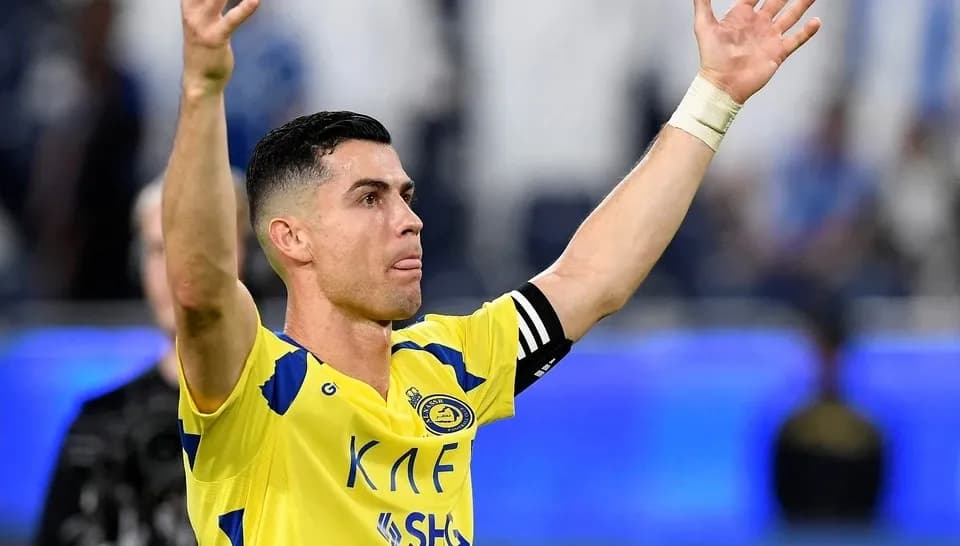 Cristiano Ronaldo trong màu áo Al Nassr, giơ tay chào khán giả, thể hiện sự tập trung vào chiến lược của đội.