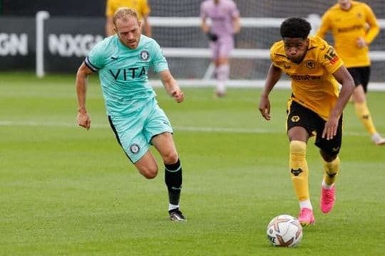 Cầu thủ đang dẫn bóng, tượng trưng cho cuộc chiến không ngừng nghỉ và ý chí vươn lên của các đội bóng.