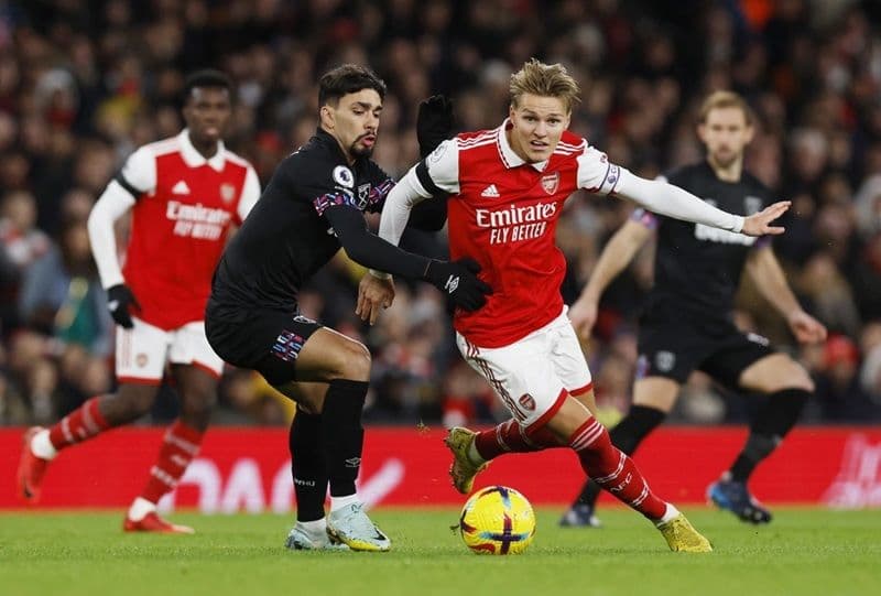 Cầu thủ Arsenal Martin Odegaard tranh bóng với đối thủ West Ham trong trận derby London.