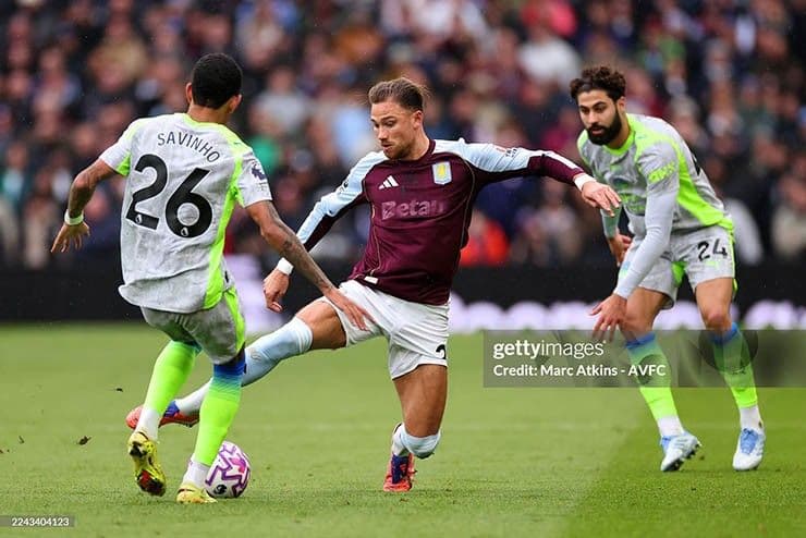 Cầu thủ Aston Villa đột phá qua hàng phòng ngự Man City, thể hiện chiến thuật tấn công.