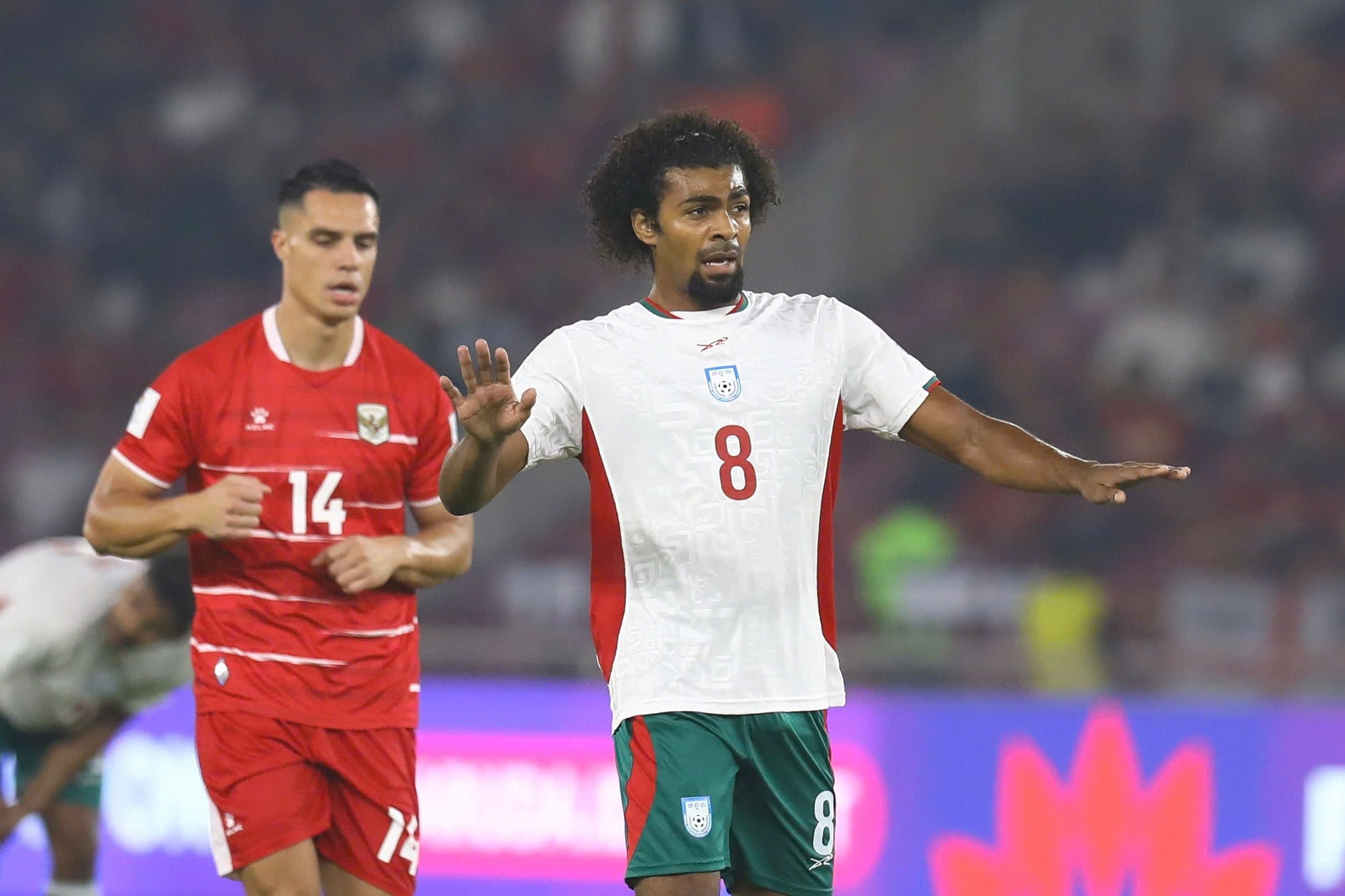 Cầu thủ Bangladesh và Indonesia tranh bóng quyết liệt trên sân, bối cảnh trận đấu có quyết định bù giờ gây tranh cãi.