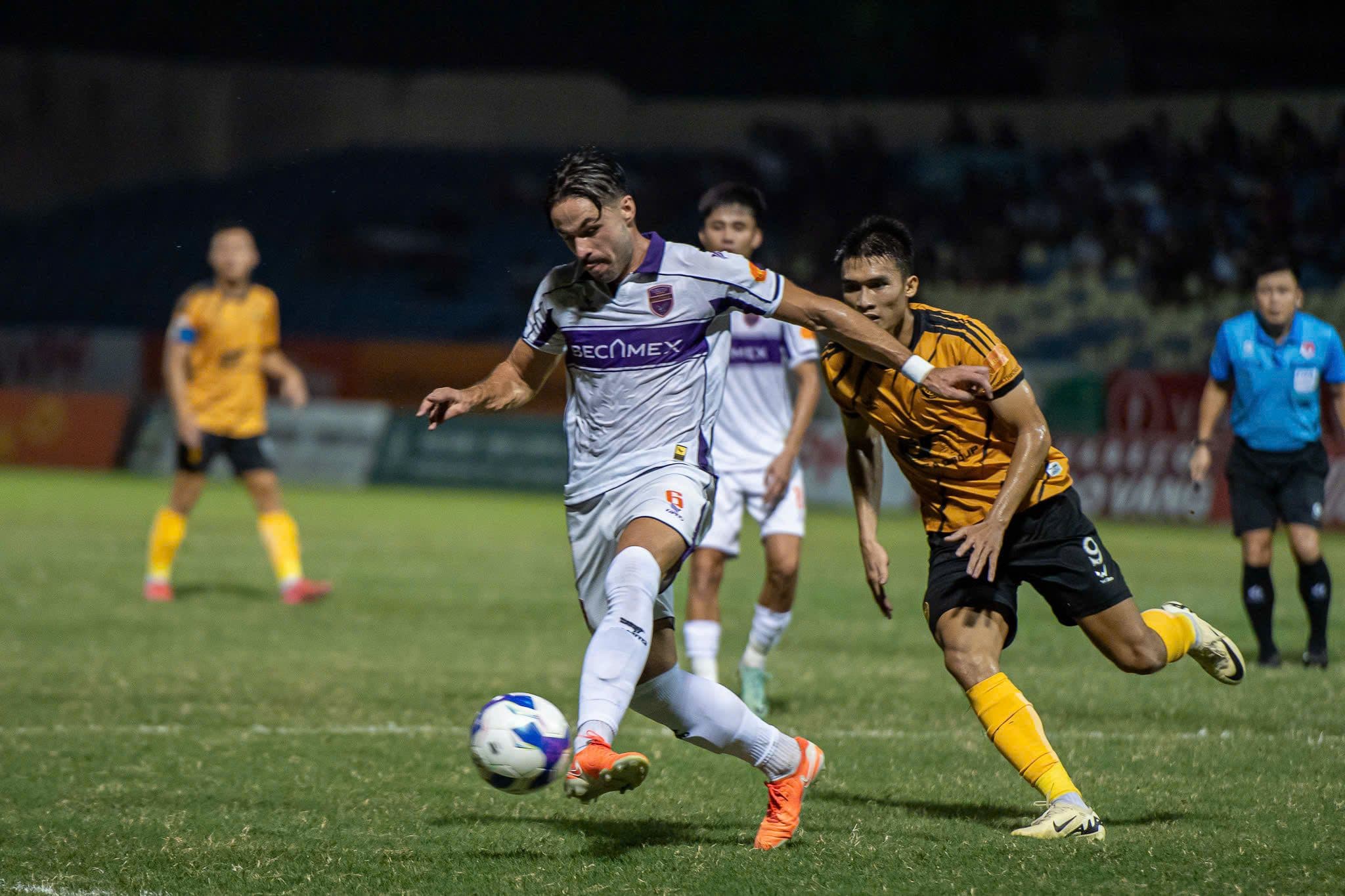 Cầu thủ Becamex TP HCM tấn công trước sự truy cản của cầu thủ Nam Định