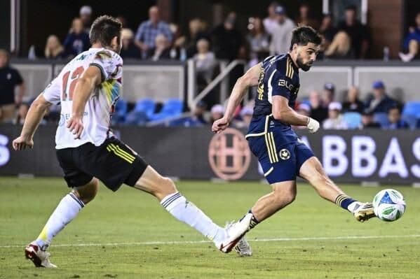 Cầu thủ bóng đá tranh bóng trên sân cỏ