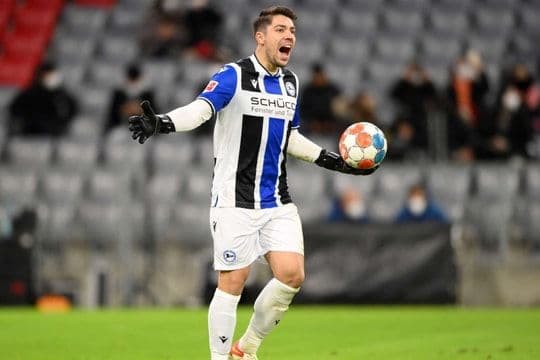 Cầu thủ bóng đá trong trang phục thi đấu đang thể hiện sự quyết tâm trên sân