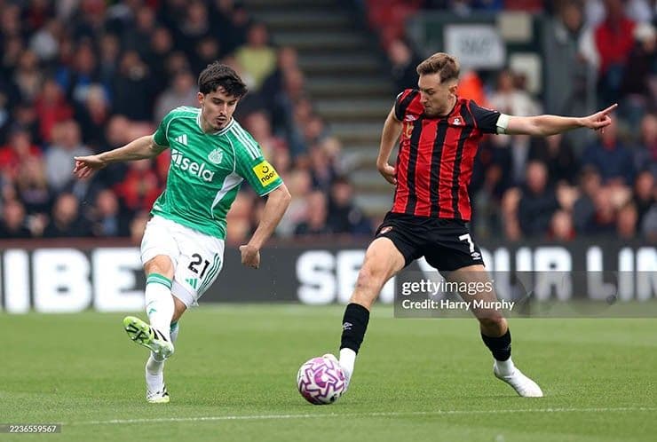 Cầu thủ Bournemouth dứt điểm trước sự truy cản của hậu vệ Newcastle, thể hiện phong độ tấn công mạnh mẽ.