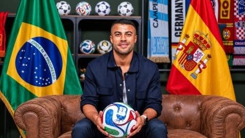 Cầu thủ Brazil Rafinha ngồi giữa lá cờ Brazil và Tây Ban Nha, tượng trưng cho di sản và sự đổi mới.